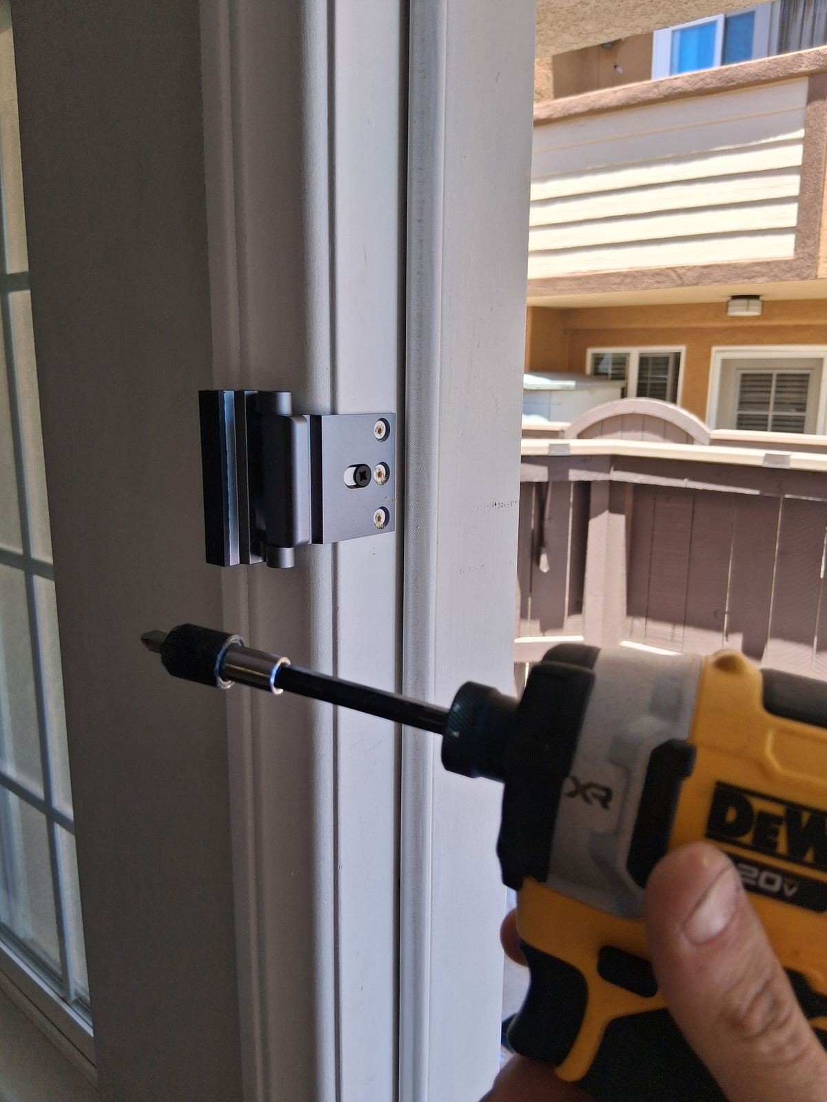 Patio door hinge and lock hardware installed